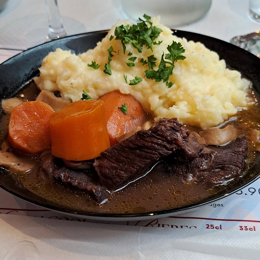 Viande mijotée, purée, carottes et champignons servis au Bouillon